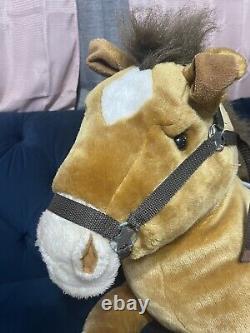 Cheval de peluche géant avec selle assis sur un coussin en peluche animal brun